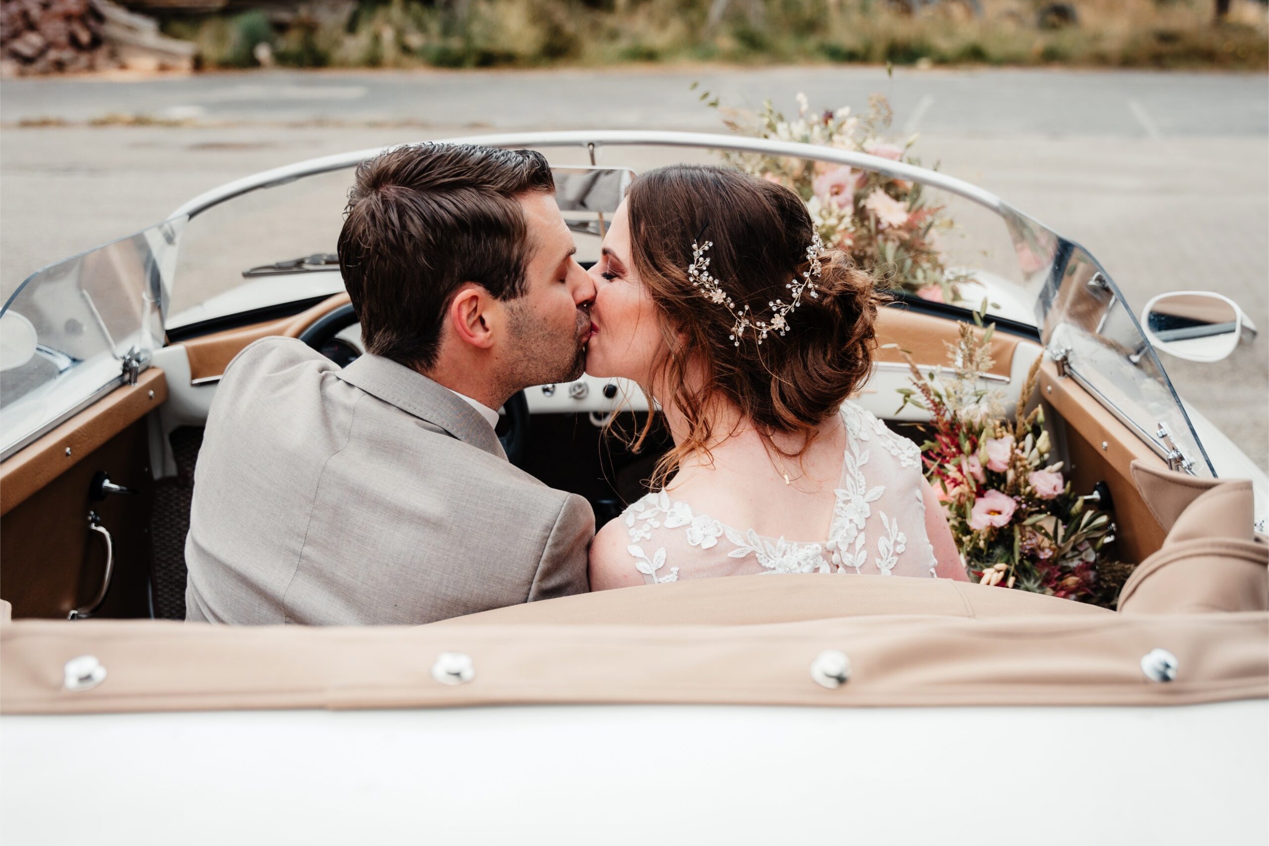 Bruid_en_bruidegom_in_witte_trouwauto_op_industrele_locatie_in_almelo-min natuurlijk portret in Overijssel